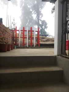 um portão vermelho em frente a um edifício em Vamoose Rhododendron em Darjeeling