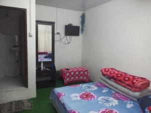 a room with a bed and a mirror at Rhododendron Homestay in Darjeeling