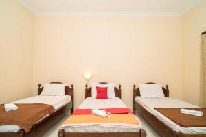 2 camas individuales en una habitación con 2 toallas en RedDoorz near Kampus 3 UTY Yogyakarta, en Yogyakarta