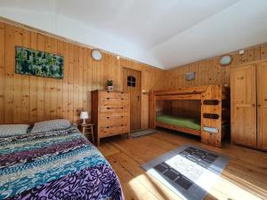 a bedroom with a bed and a wooden wall at Family Camp Ryczywół in Ryczywół
