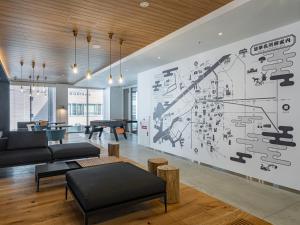 a living room with a large drawing on the wall at Granbell Hotel Osaka in Osaka