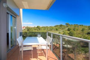 y balcón con mesa de comedor blanca y sillas. en UHC Paradise Village Family Complex, en Salou