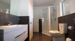 uma casa de banho com um WC, um lavatório e um chuveiro em Carramar Motor Inn em Palmerston North