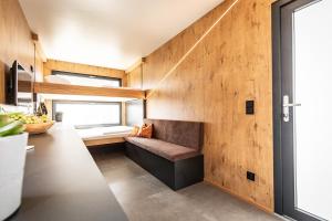 een kamer met een houten muur en een bank bij Uiferhäuser in Illmitz