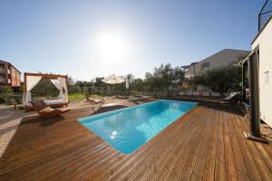 a swimming pool on a wooden deck at Villa Suncica with Heated Pool, Jacuzzi and Bikes near Zadar in Sukošan