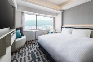 神戸市にあるレムプラス神戸三宮のベッドと窓が備わるホテルルーム