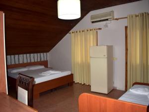 a bedroom with a bed and a refrigerator at Hotel Central in Tirana