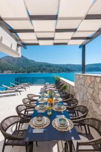 a long blue table with chairs on a patio at Ville Sol Del Mar in Slano