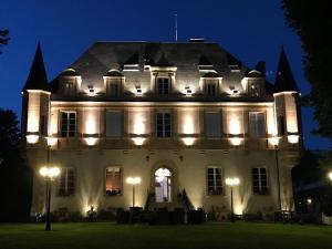 a large white building with lights on it at night at Château de Puy Robert LASCAUX - Sarlat in Montignac