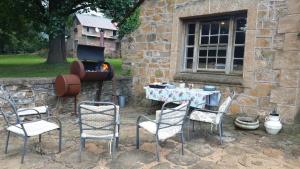 a group of chairs and a table and a grill at Old Balgowan Farm Cottage in Balgowan
