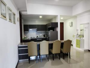 a kitchen with a table and chairs in a room at Bay Resort Condominium in Miri