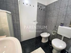 a bathroom with a white toilet and a sink at Apartment Ronaldo in Poreč