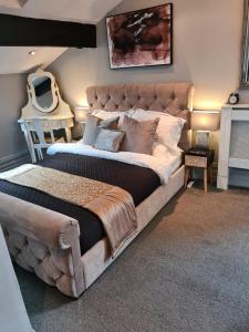 a bedroom with a large bed with a large headboard at Albert Rd Aparthotel in Colne