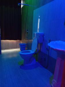 a blue bathroom with a toilet and a sink at Vamoose Raj Palace in Bharatpur