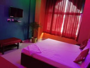 a bedroom with a large bed with pink lighting at Raj Palace in Bharatpur