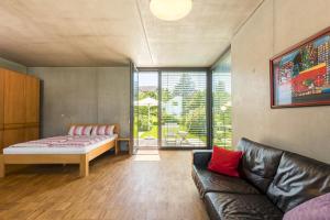 sala de estar con sofá y cama en Mettnau-apartment, en Radolfzell am Bodensee