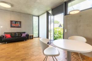 sala de estar con mesa blanca y sillas en Mettnau-apartment, en Radolfzell am Bodensee