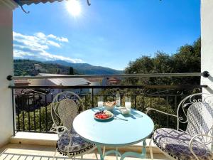 una mesa y sillas en un balcón con vistas en Sunflower Apartments & Studios en Kassiopi