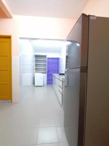 a kitchen with a refrigerator and a tile floor at Mui Gim Homestay 大港 美景民宿 in Sungai Besar