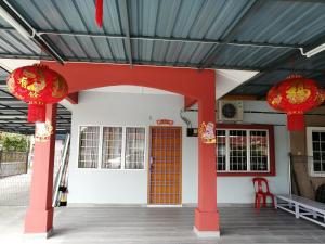ein Gebäude mit roten Säulen und einer roten Tür in der Unterkunft Mui Gim Homestay 大港 美景民宿 in Sungai Besar