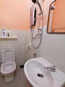 a bathroom with a toilet and a sink and a shower at Mui Gim Homestay 大港 美景民宿 in Sungai Besar