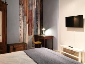 a bedroom with a bed and a desk and a television at Casa 28 in Bologna