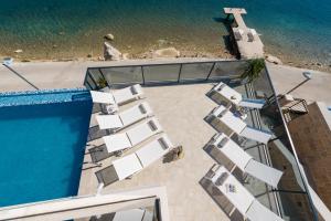 an overhead view of lounge chairs next to a swimming pool at Ville Sol Del Mar in Slano