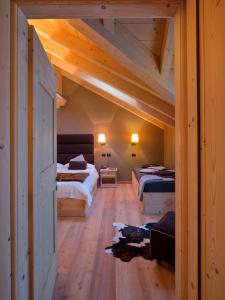 una camera con due letti in una stanza con soffitti in legno di Agriturismo Rini a Bormio