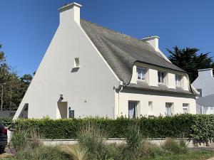 ein weißes Haus mit schwarzem Dach in der Unterkunft Ar Marc'h-Mor Glaz 3 étoiles in Cléder