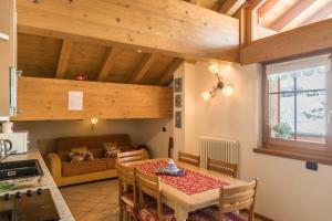 een keuken en eetkamer met een tafel en een bank bij Nadir - Casa Azzurra in Livigno