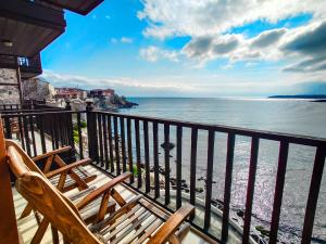 two chairs sitting on a balcony looking at the ocean at Hotel Casa del Mare in Sozopol