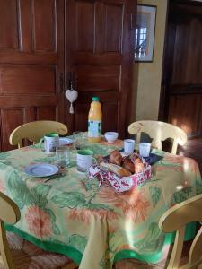 a table with a basket of bread and a bottle of juice at chambre dans Prieuré de caractère XVIII siècle in Planioles