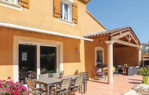 a patio with a table and chairs in front of a building at VILLA FLAMENCA - piscine chauffée in Châteaurenard