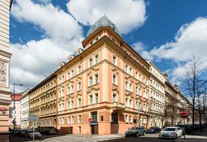 布拉格的住宿－Sibelius Apartments，一座大型建筑,前面有汽车停放