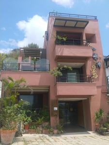 a pink building with plants in front of it at A&L Inn 戀灣旅棧 in Nanwan