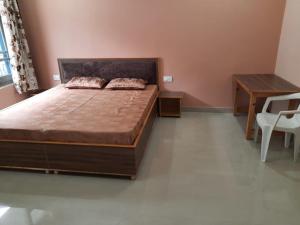 1 dormitorio con 1 cama grande y escritorio en BHAGSU HOME STAY en Dharamshala