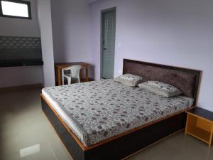 um quarto com uma cama, uma mesa e uma cadeira em BHAGSU HOME STAY em Dharamshala