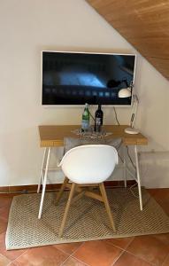 a white chair sitting in front of a desk with a television at Oldenburger Mühle in Oldenburg