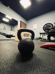 a black dumbbell sitting on the floor of a gym at Hotel Europa in Chivasso