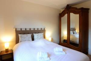 ユナヴィールにあるLe Verger - Maison de vacances Route des Vinsのベッドルーム(大きな白いベッド1台、鏡付)