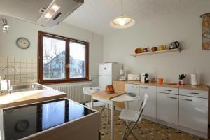 a kitchen with a sink and a table with chairs at Le Verger - Maison de vacances Route des Vins in Hunawihr