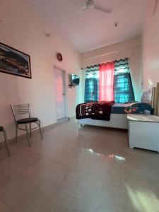 ein Schlafzimmer mit einem Bett und einem Stuhl in einem Zimmer in der Unterkunft CITY CROWN GUEST HOUSE in Sundarnagar