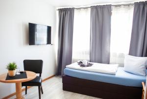 ein Hotelzimmer mit einem Bett, einem Tisch und einem Fenster in der Unterkunft Waldhotel König von Rom in Waldesch
