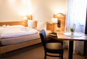 um quarto com uma cama, uma secretária e uma mesa com uma cadeira em Waldhotel König von Rom em Waldesch