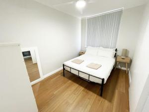 
a bedroom with a white bed and white walls at Studio 101 in Fremantle
