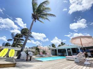 a resort with a palm tree and a swimming pool at Villa Horizon Lointain - Private beach and pool with sea view in Cul de Sac