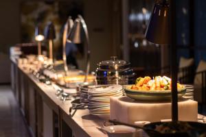 a buffet line with plates and a bowl of food at InterContinental Phuket Resort by IHG in Kamala Beach