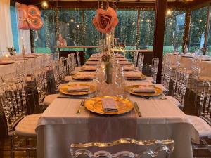 a long table with plates and vases with roses on it at Country House Corte Del Sole in Campolungo +31 photos