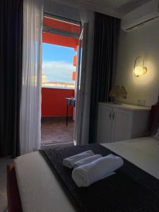 - une chambre avec 2 serviettes sur un lit et une fenêtre dans l'établissement Marble Apartments, à Oradea