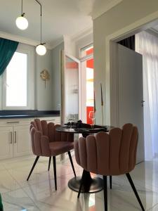 - une salle à manger avec une table et des chaises dans l'établissement Marble Apartments, à Oradea